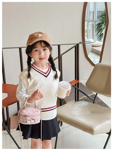 Pink quilted chain handbag for children shown in a stylish cafe outfit setting
