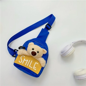 Close-up of blue children's chest bag featuring a 3D plush bear and SMILE text