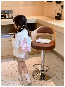 Sac à main fille en tweed rose avec nœud satin et anse en perles dans un café chaleureux