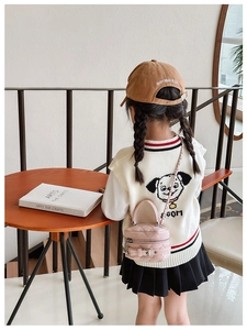 Pink quilted mini bag with belt buckle detail shown on a stylishly dressed child model