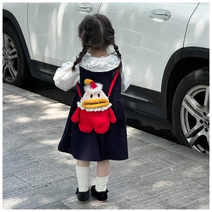 Détail d'un sac bandoulière canard en crochet rouge avec bonnet de Noël pour petites filles