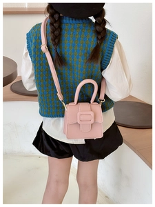 Pink lychee texture mini saddle bag shown on child model with adjustable shoulder strap