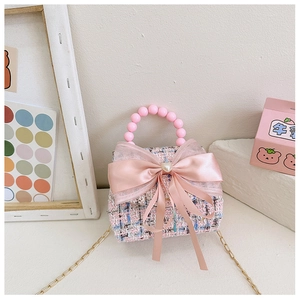 Détail de la texture en tweed rose et nœud fait main avec perle de cœur sur sac de fille