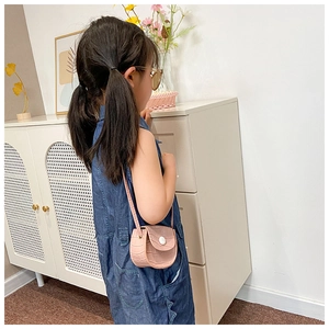 Detail view of pink PU leather saddle bag with crocodile pattern on a little girl