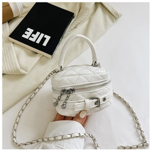 Macro detail of white quilted leather mini bag with silver chain strap and belt buckle decor