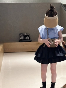 Fashionable toddler outfit featuring a blue ruffled shirt and black tiered tutu skirt