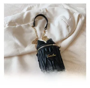 Détail du sac seau noir plissé avec bandoulière chaîne dorée et motif cœur True Love