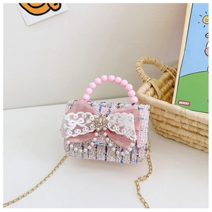 Dettaglio borsa in tweed rosa per bambina con fiocco in pizzo e ciondolo di perle