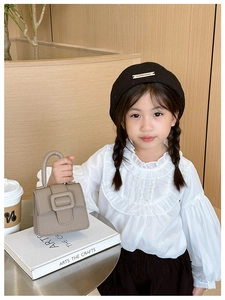 Detail of a khaki lychee pattern mini saddle bag held by a girl in sweet style