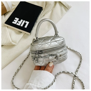 Detail of silver quilted leather mini bag with double zippers and metal chain strap