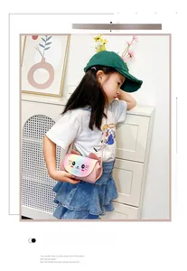 Detailed view of pink cat crossbody bag with rainbow sequins worn by a young child