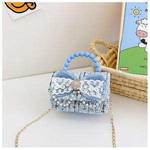 Dettaglio borsa bimba in tweed blu con fiocco in pizzo e manico di perle
