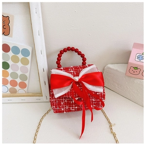 Détail du mini sac en tweed rouge avec nœud en perles et chaîne dorée