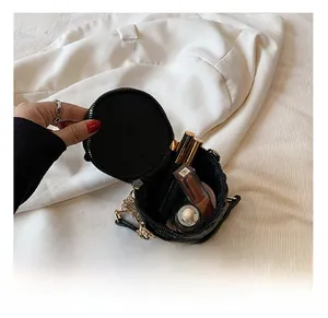 Capacité interne du mini sac rond matelassé noir montrant l'espace pour le maquillage