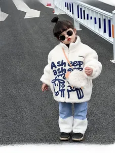 Détail de la veste enfant en polaire crème douce avec motif mouton bleu et broderie