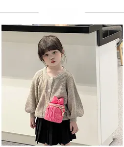 Pink quilted crossbody child bag with bow and heart pattern shown on young model