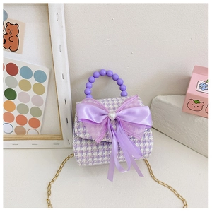 Détail du mini sac en tweed lavande avec nœud, boucle cœur perle et anse perlée