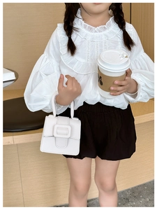Detail of white lychee texture mini saddle bag with decorative buckle for girls