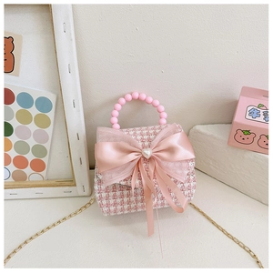 Détail du mini sac fille en tweed rose avec nœud en satin et cœur en perle