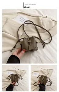 Detail of khaki drawstring bucket bag with litchi grain leather and gold hardware