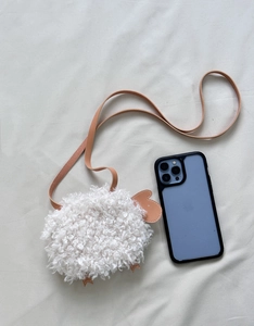 Détail du sac bandoulière mouton en laine d'agneau avec comparaison de taille par mobile