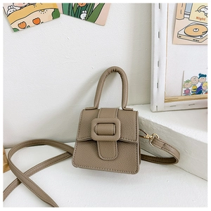 Close-up of litchi texture leather mini saddle bag with buckle on white display stand