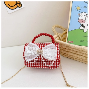 Dettaglio della borsa in tweed rosso da bambina con manico di perle e fiocco in pizzo