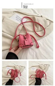 Detail view of rose pink bucket bag with lychee texture and gold buckle hardware
