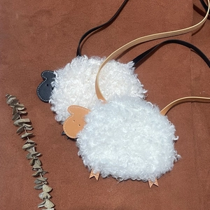 Détail des sacs à bandoulière mignons en peluche d'agneau en noir et kaki