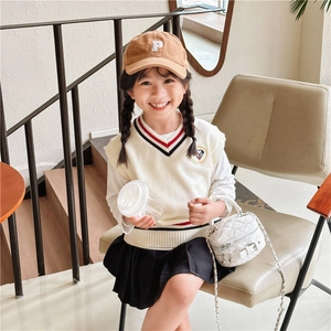 Preppy style girls' set featuring knit vest, pleated skirt and chain crossbody bag