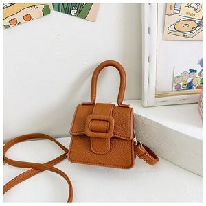 Detail of dark brown lychee grain mini saddle bag with vintage horseshoe buckle