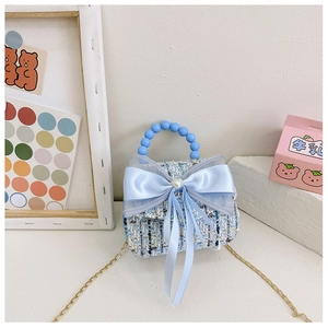 Détail du sac en tweed bleu pour fille avec nœud en satin et perle en forme de cœur