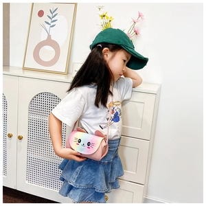 Detail of pink rainbow cat crossbody bag with cute ears worn by a child model
