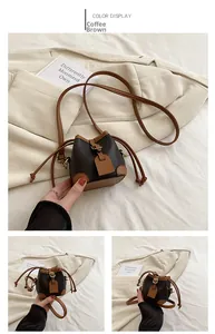 Detail of coffee brown mini drawstring bucket bag with adjustable leather shoulder strap