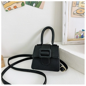 Detail of black litchi texture mini saddle bag with metal buckle and top handle