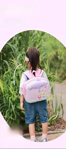 Rear view of a girl wearing the pink cartoon castle backpack with padded straps
