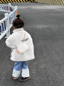 Détail du sac bandoulière agneau en peluche avec veste polaire et jean en denim