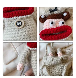 Detail showing handcrafted knit monkey bag with pearl necklace and red lips accents