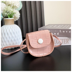 Close-up of pink faux crocodile leather mini round bag with white snap button closure