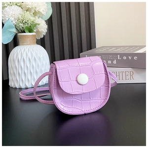 Detailed macro view of purple mini crossbody bag with embossed crocodile texture and button