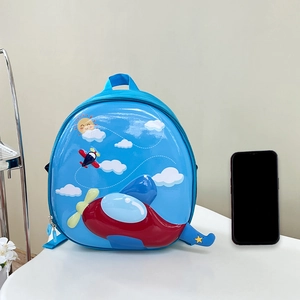 Blue hard shell kids backpack with 3D airplane design and phone for size reference