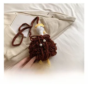 Detail showing the handmade crochet ostrich bag with yellow legs and pearl accents