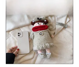 Handmade crochet cartoon doll bag with red sausage lips compared to a smartphone for size