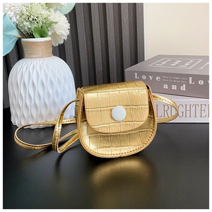 Detailed macro view of mini golden bag with crocodile pattern and white snap button