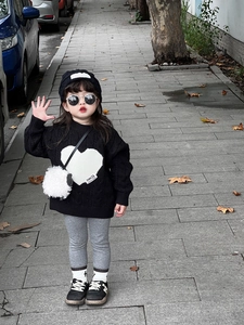 Détail du sac bandoulière agneau en peluche blanche avec un pull en maille à cœur