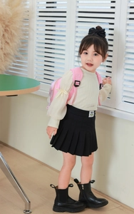 Pink cartoon eggshell backpack styled with a white top and black pleated skirt
