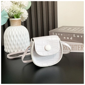 Detail of white PU mini crossbody bag for girls with faux crocodile texture and snap closure
