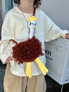 Detail of handmade crochet ostrich bag for kids with brown wool and gold bead chain
