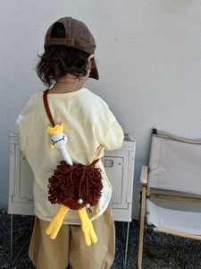 Detailed view of a handmade crochet ostrich crossbody bag with a cute crown on a child