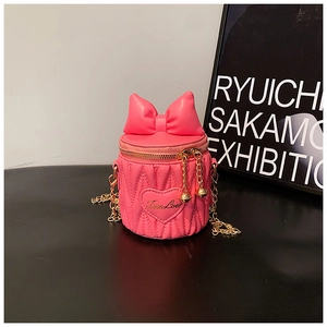 Detailed view of pink quilted mini bucket bag with leather bow and golden chain strap